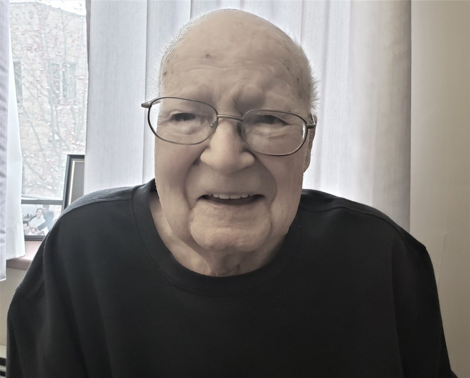 Portrait of elderly man wearing black shirt and glasses smiling